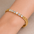 Gold bracelet with clear stones on a wrist against a neutral background