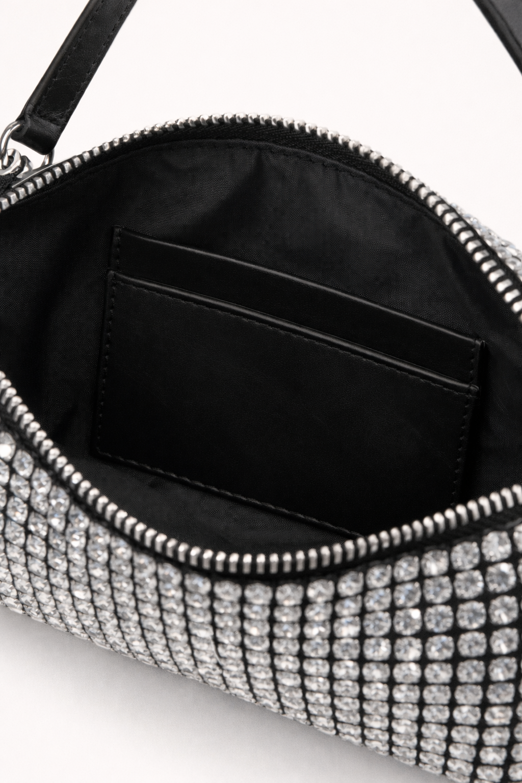 Close-up of a black handbag with silver embellishments on a white background